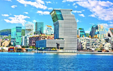Moderne Architektur in Oslo, Norwegen, spiegelt sich im blauen Wasser. Das Munch Museum (Munchmuseet) sticht mit seinem einzigartigen Design hervor. Wolkenloser Himmel.