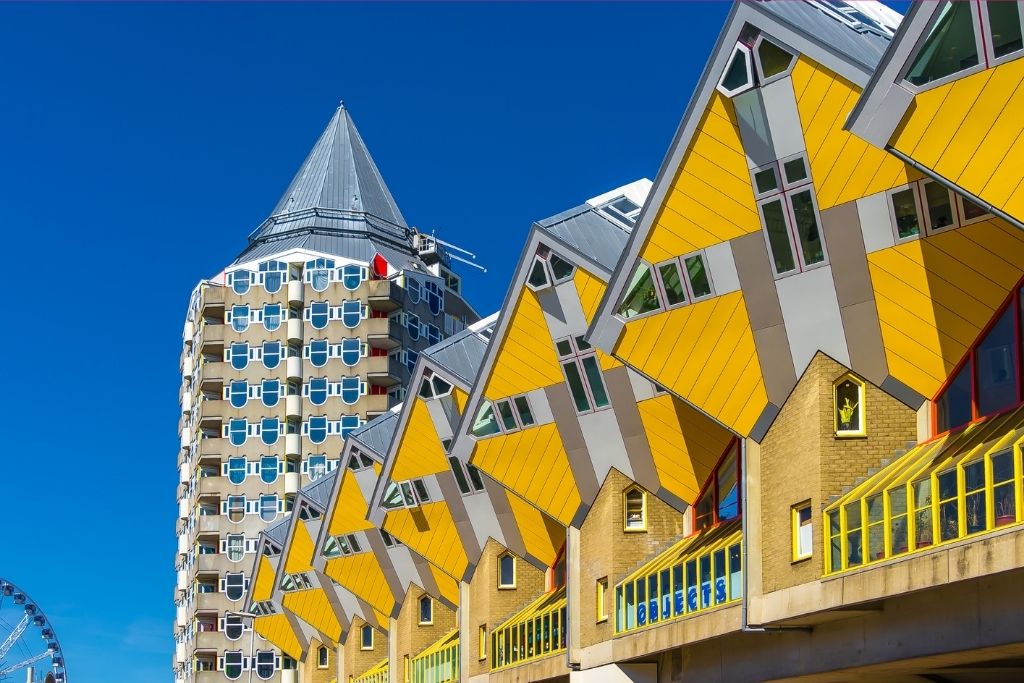 Rotterdam Kubushäuser: Gelbe Würfelhäuser und ein Turm unter blauem Himmel. Einzigartige Architektur in den Niederlanden.