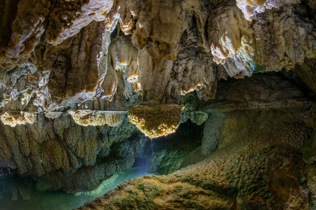 Mystische Grotte in der Schweiz: Stalaktiten und Stalagmiten spiegeln sich im klaren Wasser. Ein verborgener Schatz nahe des Vierwaldstättersees, Luzern und Rigi.
