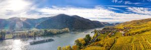 Herbstliches Panorama des Wachautals mit Schiffen auf der Donau nahe der Stadt Weißenkirchen, Österreich.