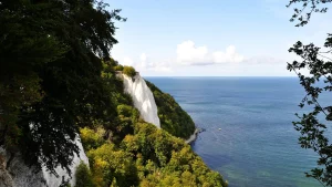 Kreidefelsen auf Rügen, eingebettet in üppiges Grün, mit Blick auf die Ostsee und den Horizont.